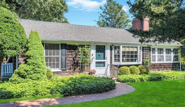 Beautiful cottage on meticulously maintained lawn, surrounded by.